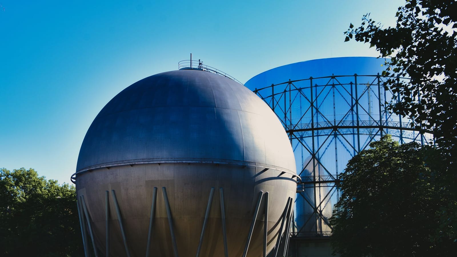 Gasometers in Pforzheim, Germany under a clear blue sky, showcasing industrial architecture.