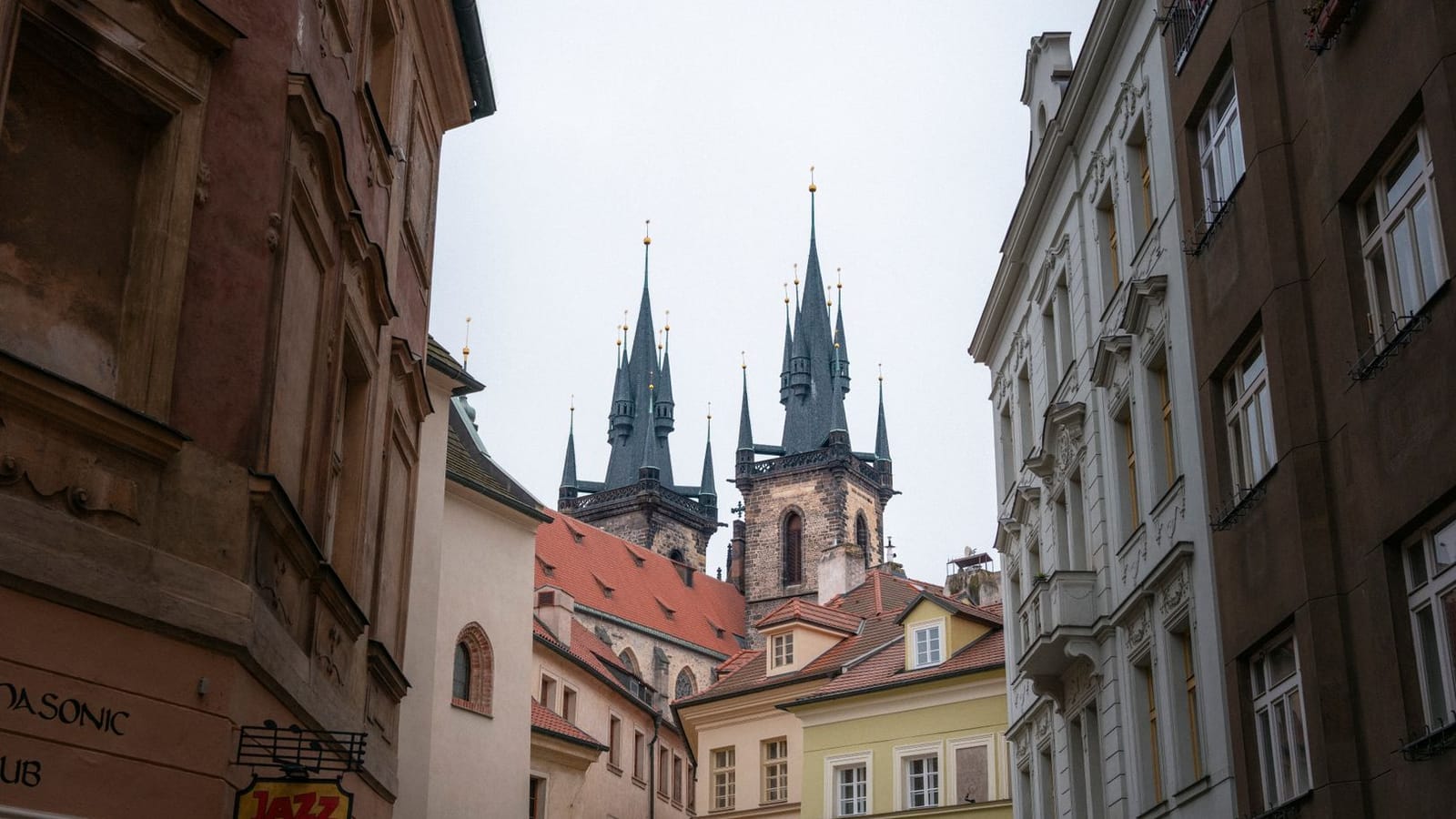 Captivating view of church spires in Prague's historic Old Town framed by traditional European architecture.
