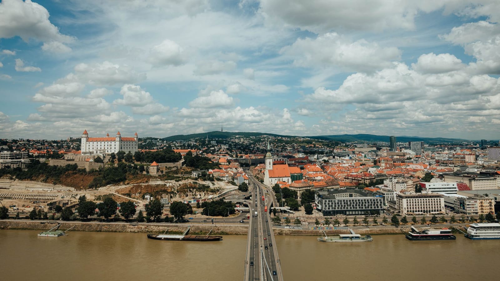 A breathtaking aerial shot of Bratislava's city skyline featuring the Danube River and iconic landmarks.