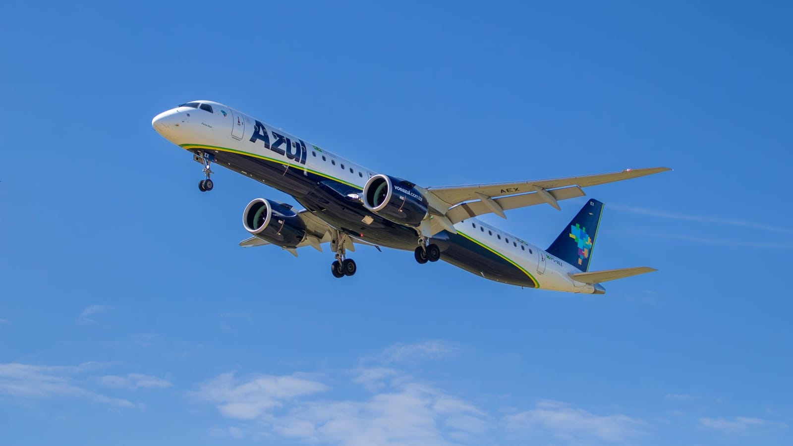 High-angle view of a commercial airplane in flight against a clear blue sky.