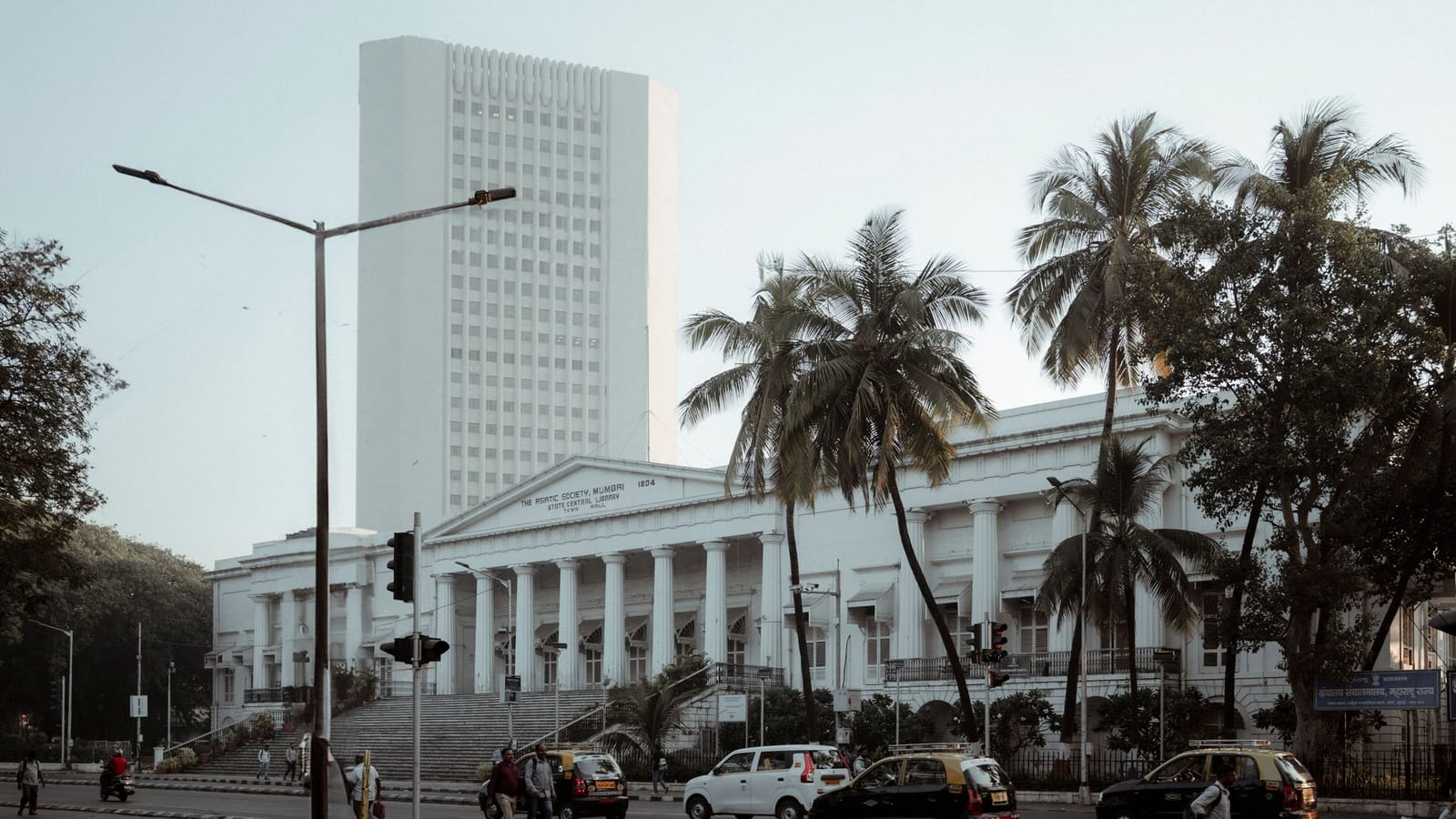 The architectural beauty of Mumbai's historic Asiatic Society Library surrounded by palm trees.