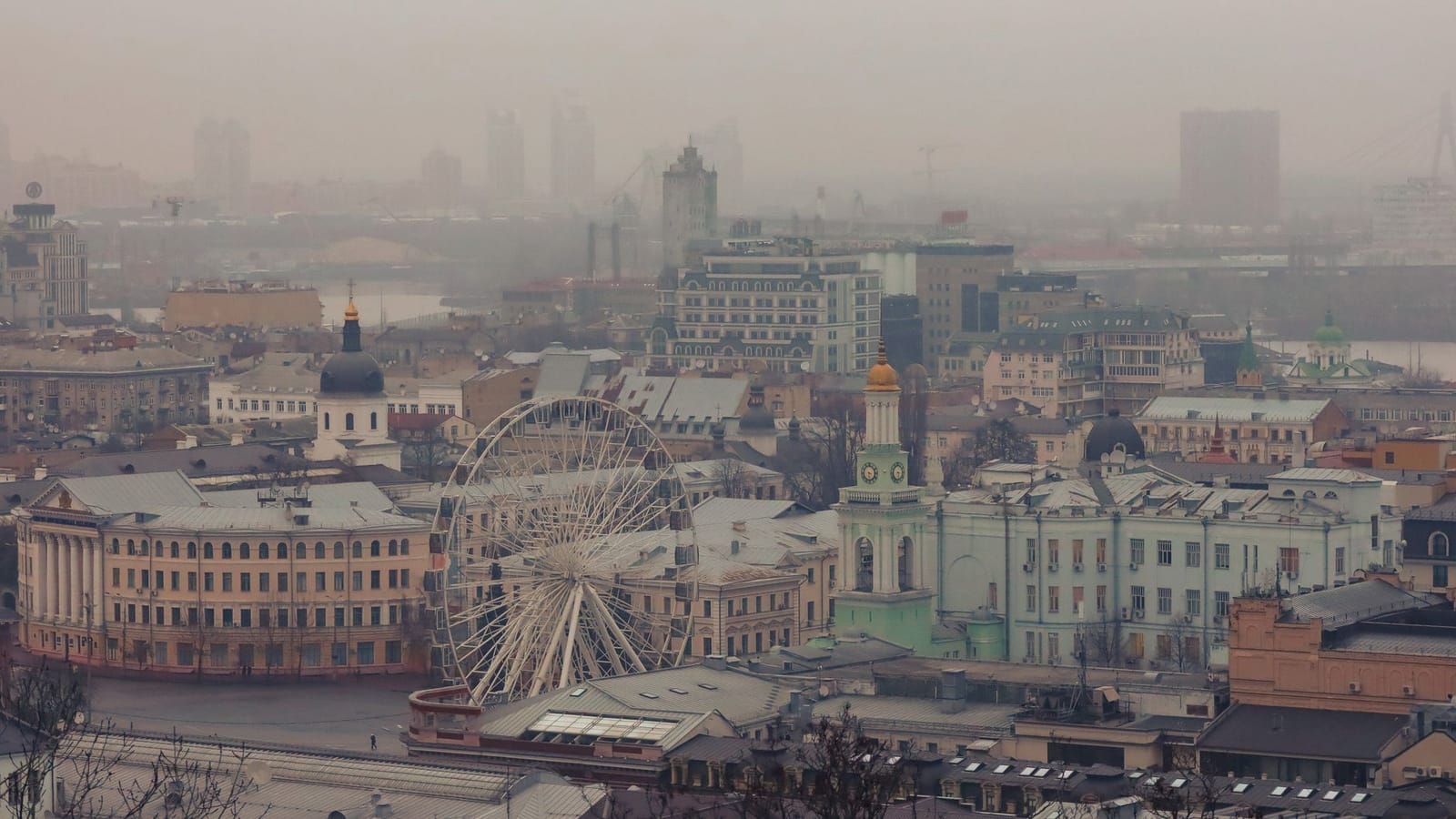 A foggy aerial view of Kiev, Ukraine, showcasing the urban landscape with a Ferris wheel.