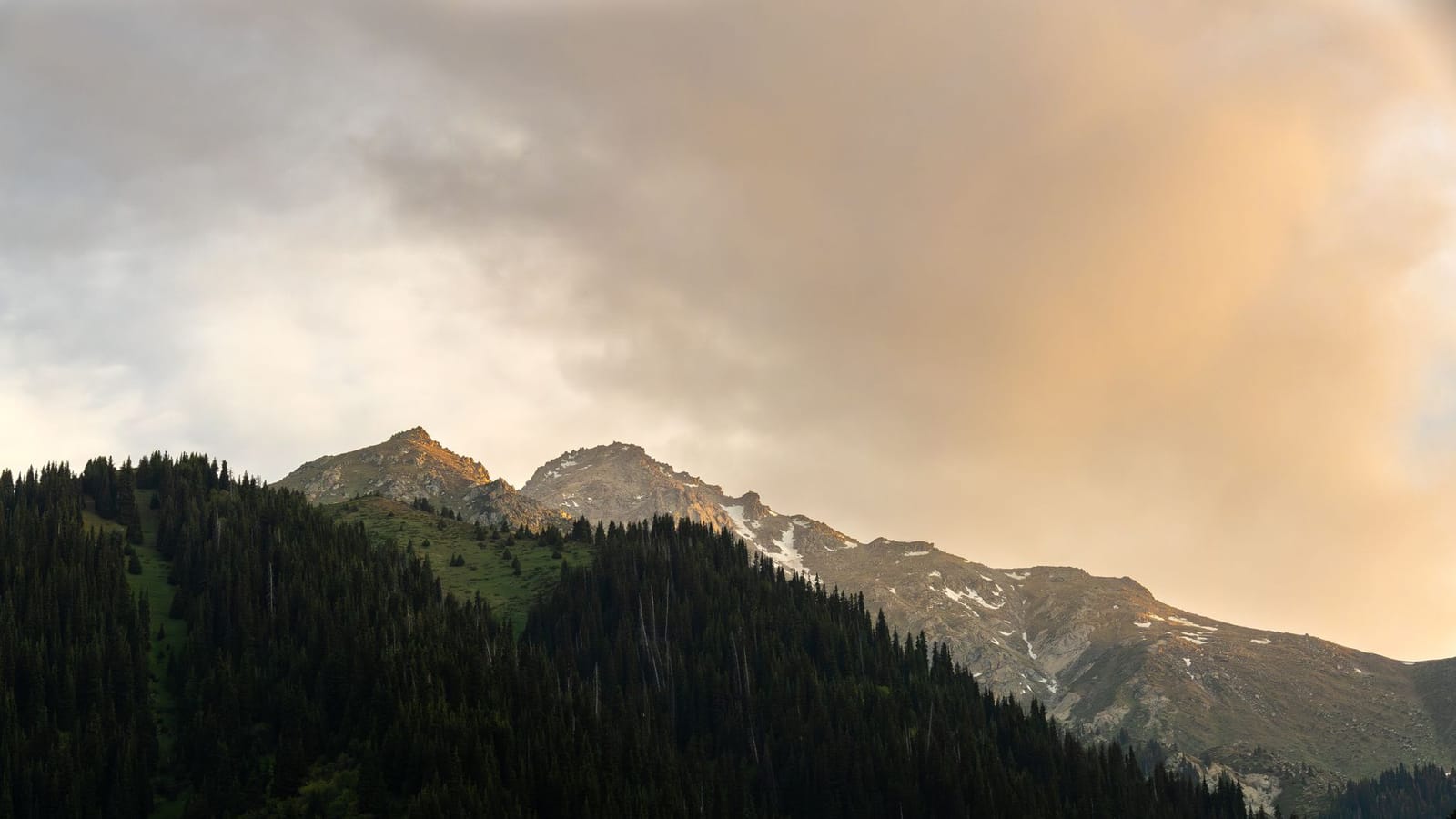Captivating sunrise over snow-capped mountains in Almaty, showcasing nature's beauty.