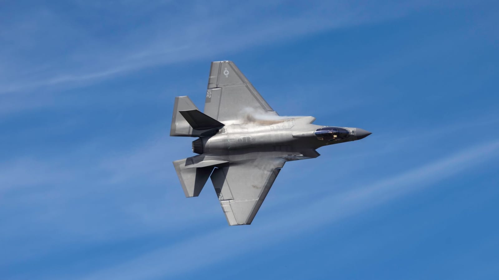 F-35 Lightning II jet soaring above Kernville, CA against a clear blue sky, showcasing its sleek design.