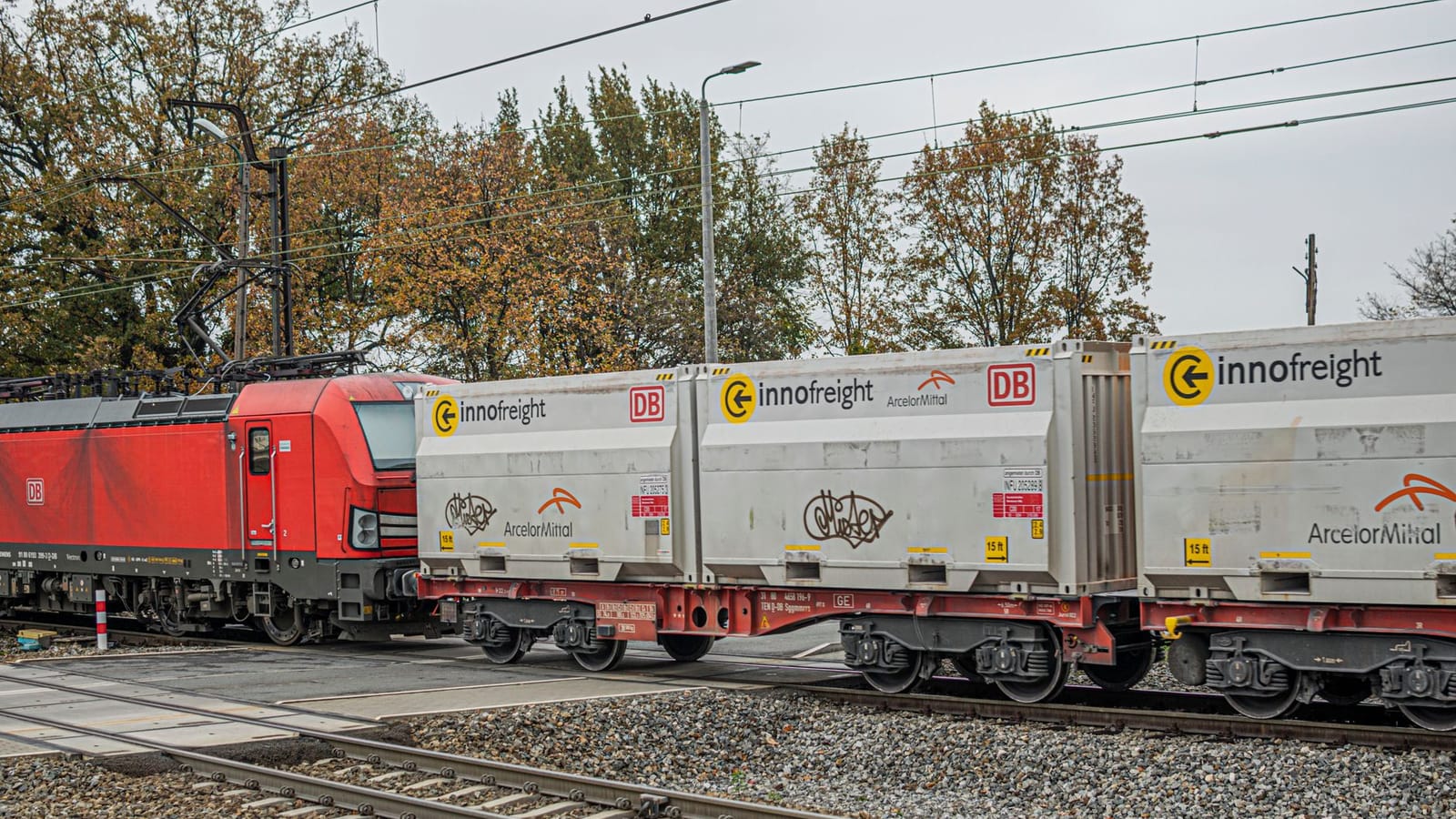 Freight train with Innofreight containers on tracks during autumn.