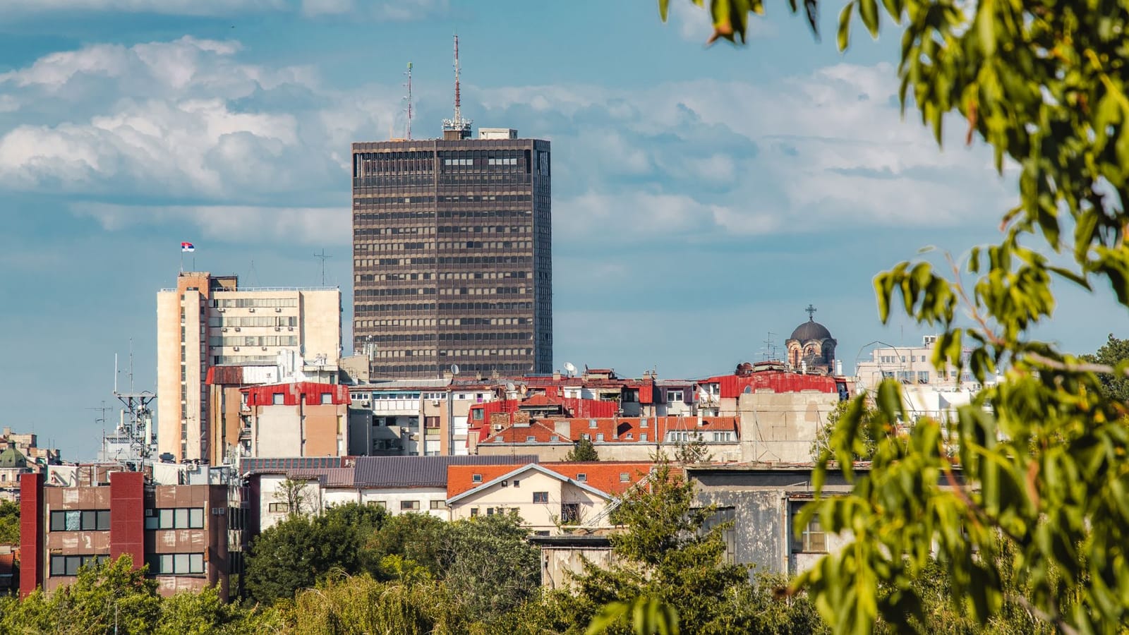 Skyline view of Belgrade with a mix of modern and classic architecture under a bright sky.