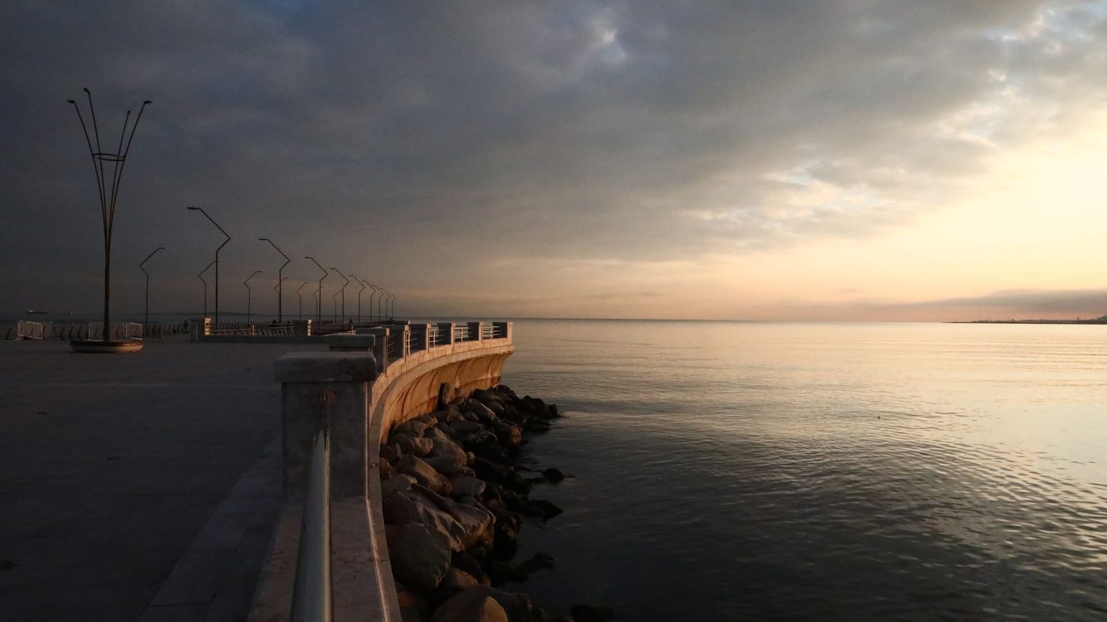 A tranquil view of Baku's seaside promenade during a captivating sunset.