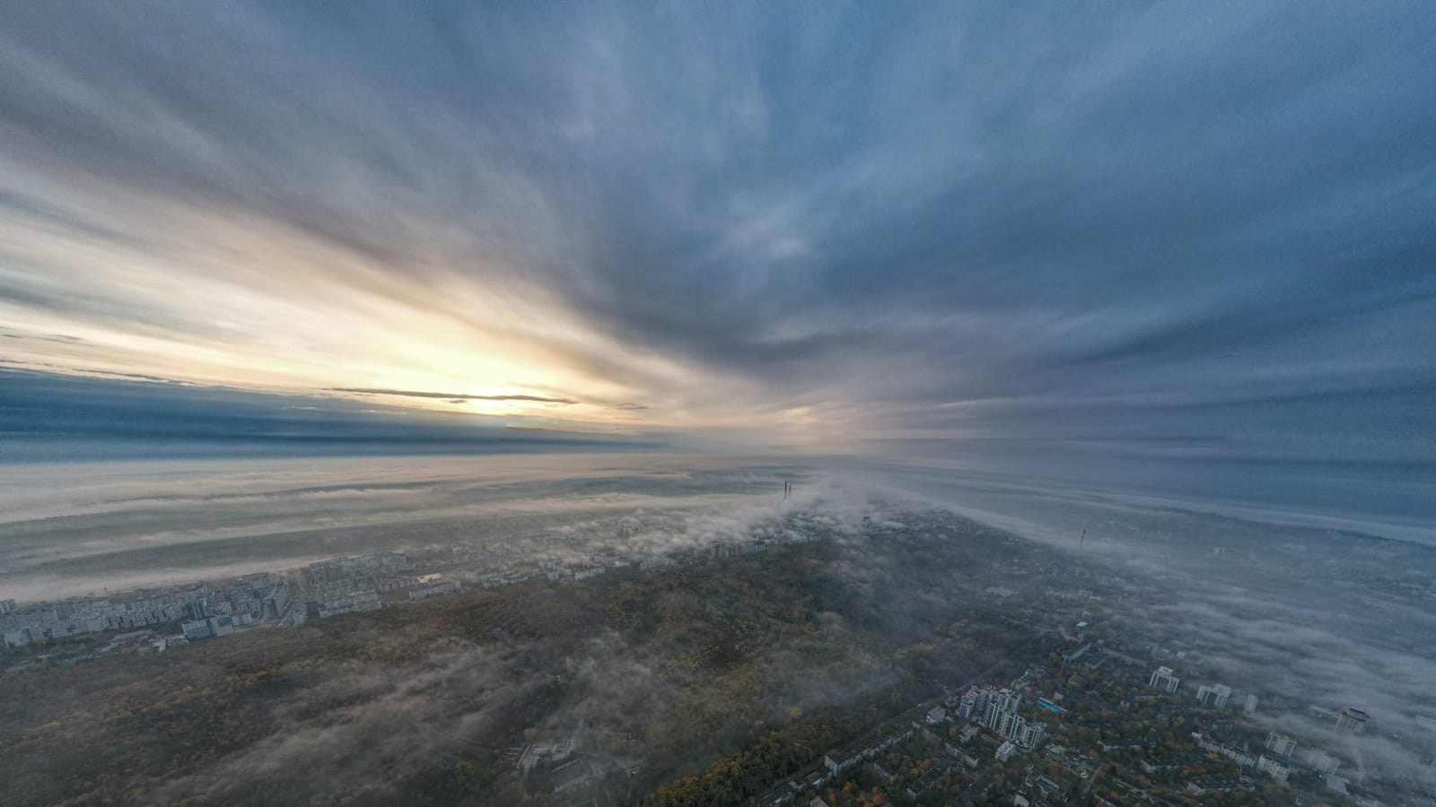 Breathtaking aerial view of Chișinău, Moldova at sunrise. Cityscape shrouded in mist and clouds.