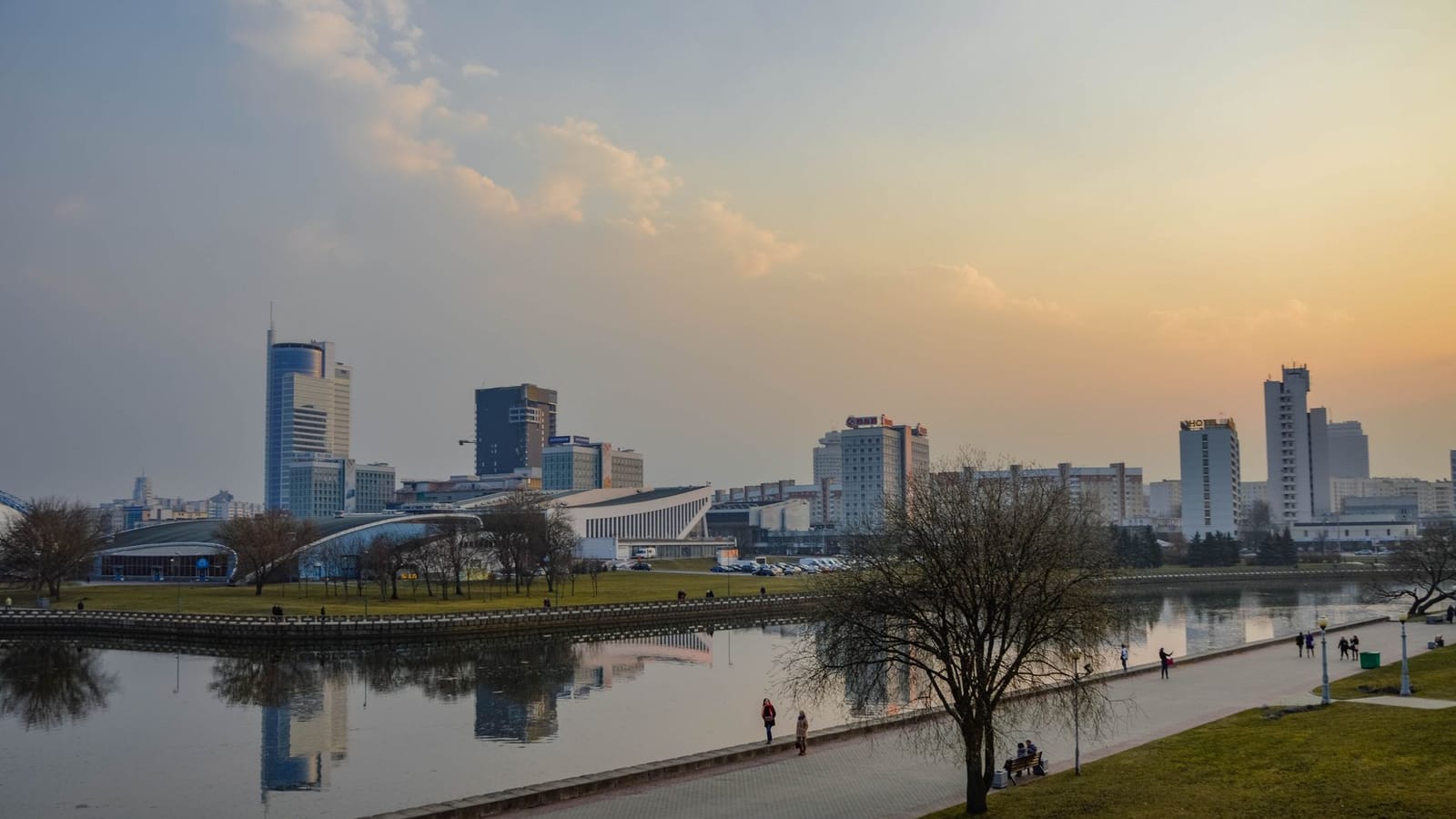 A stunning city skyline reflects in a river during sunset, capturing urban tranquility and beauty.