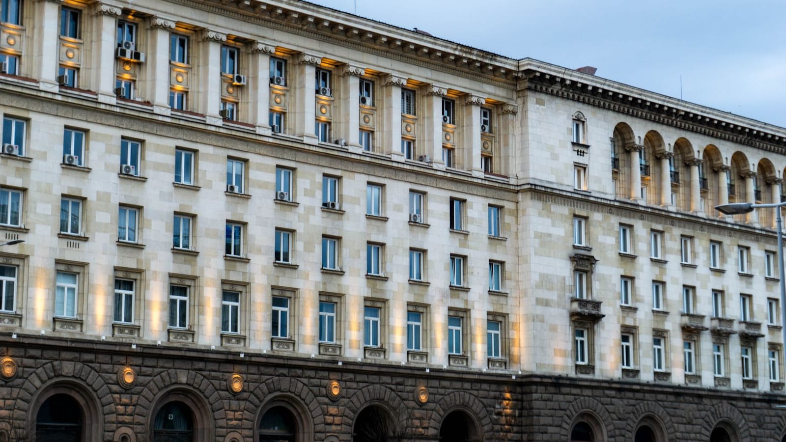 Illuminated government building in Sofia, showing classic architectural design under a twilight sky.