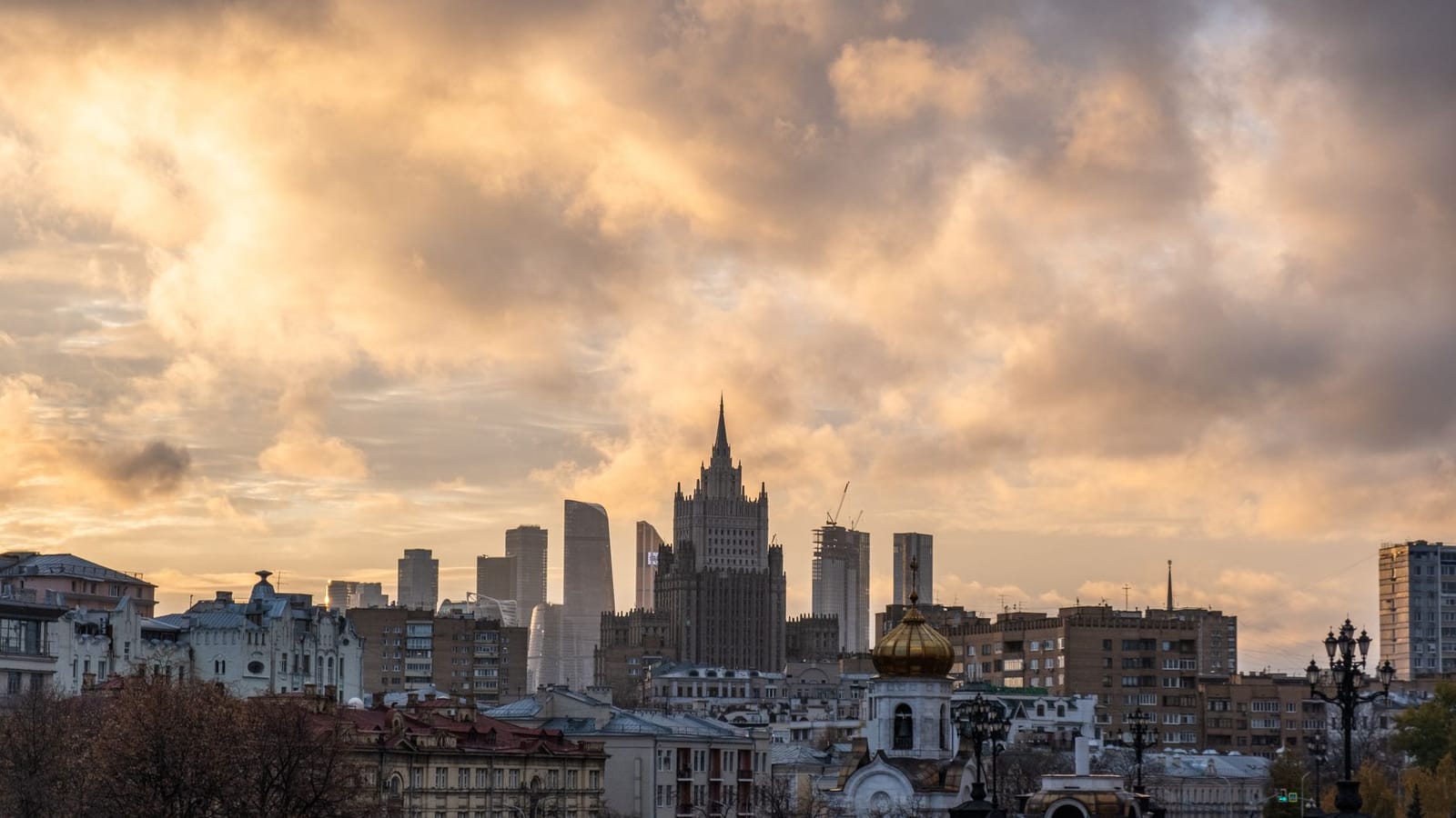 Urban cityscape of Moscow with dramatic clouds at sunset highlighting the skyline and architecture.
