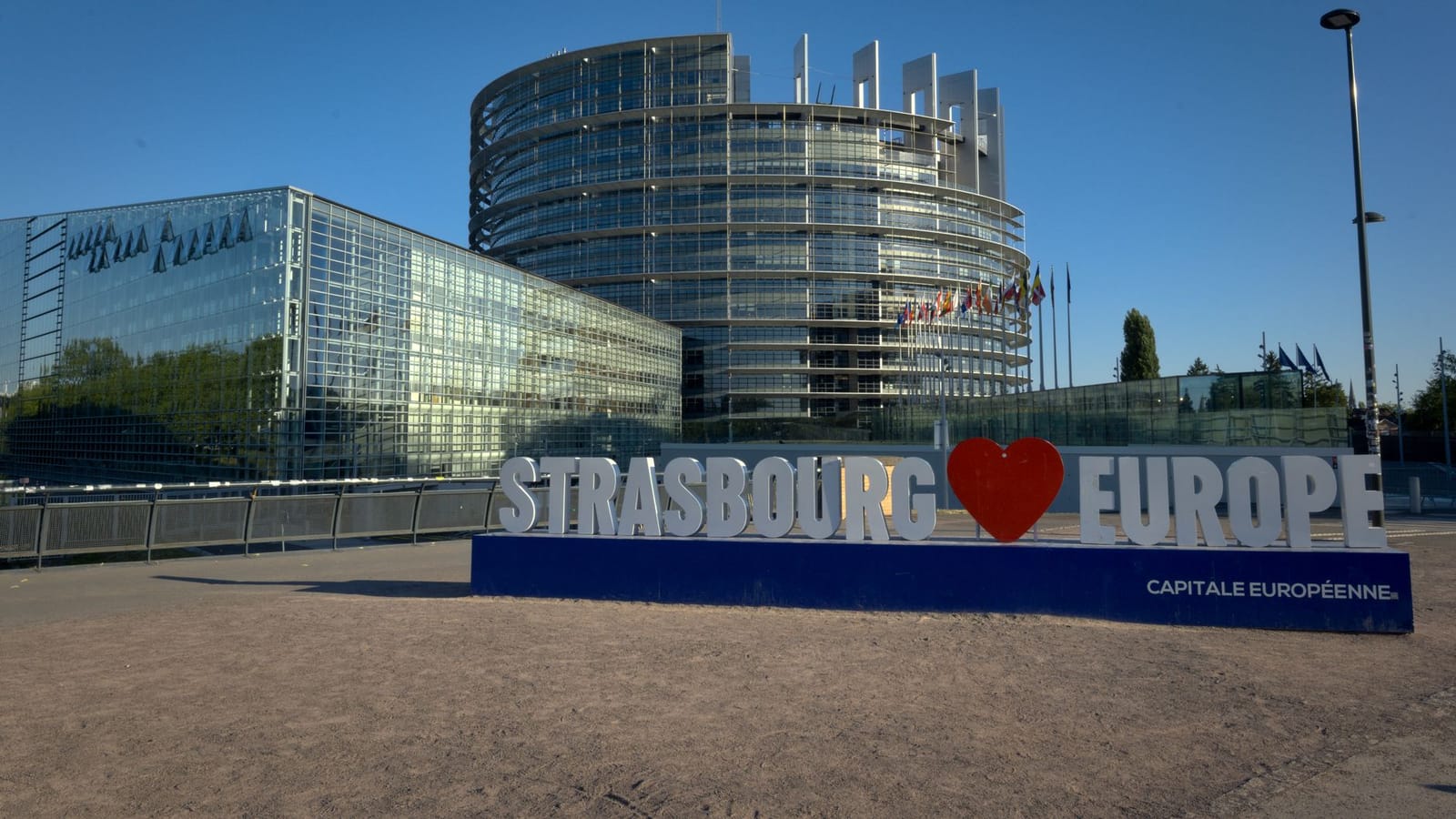European Parliament building in Strasbourg with a famous sign in front.