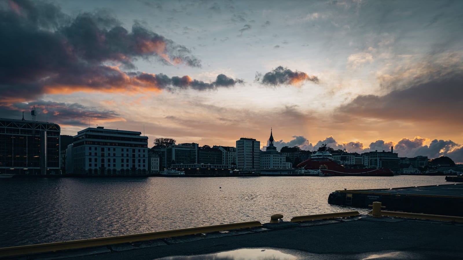 A breathtaking view of the city skyline at sunset with vibrant skies reflecting in the river.