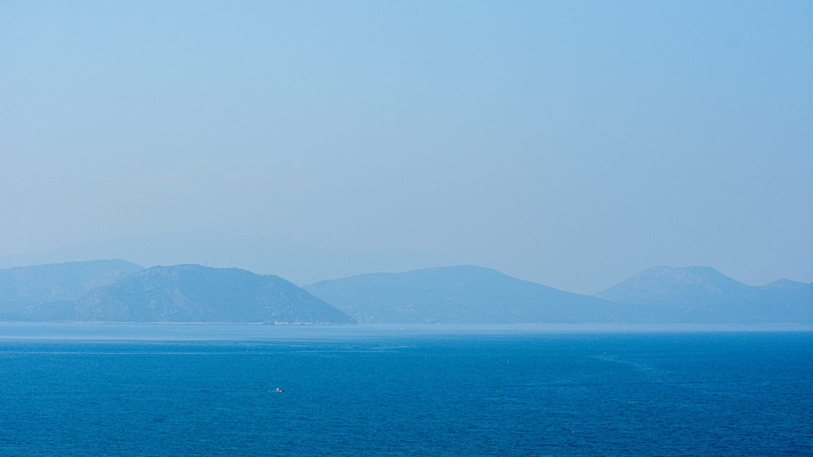 Serene view of the Aegean Sea with distant hills from Güzelçamlı, Türkiye.