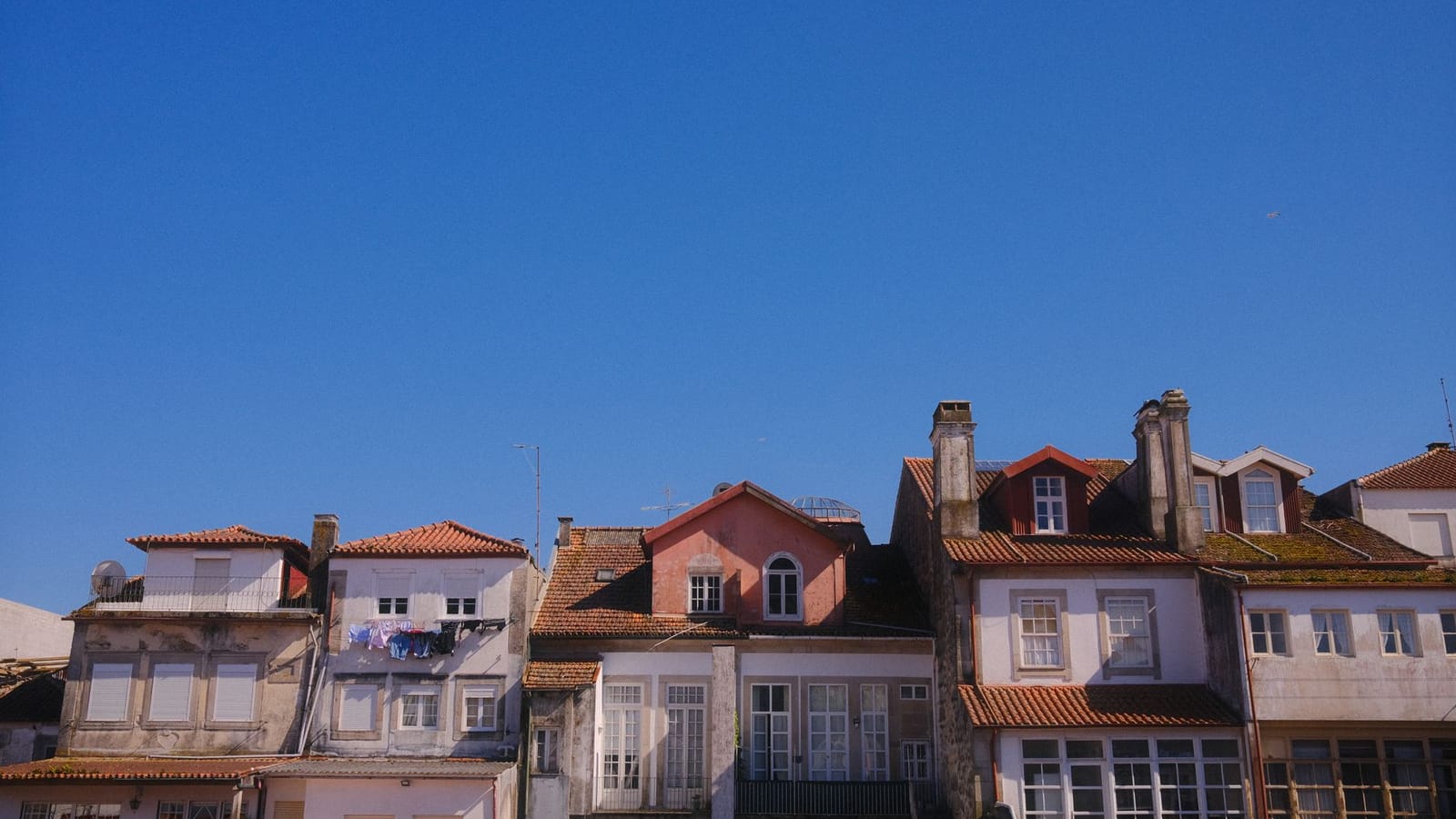 Picturesque view of colorful rooftops against a clear blue sky in Viana do Castelo, Portugal.