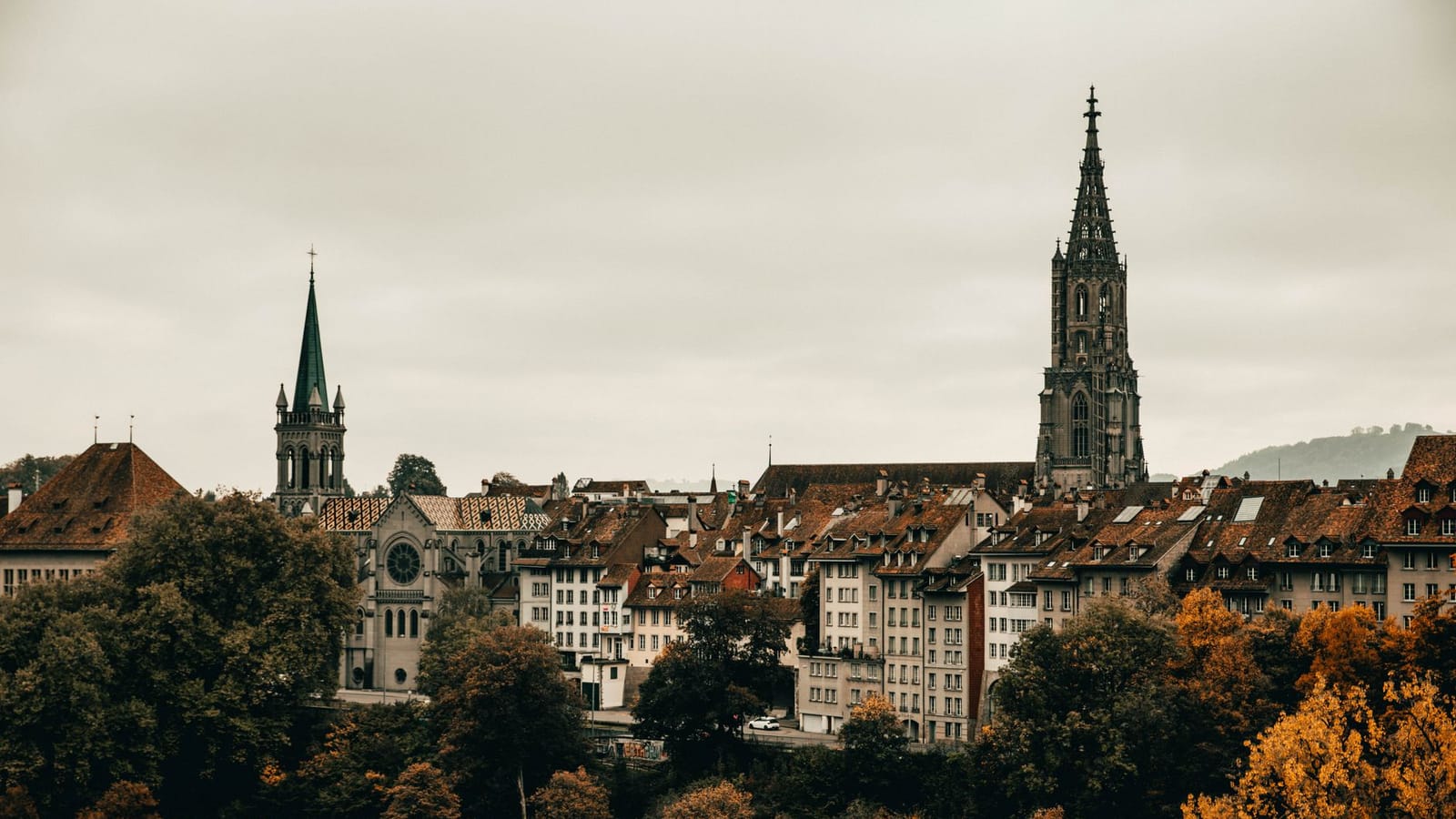 Explore the gothic architecture and vibrant autumn colors of Berne's cityscape from an elevated viewpoint.
