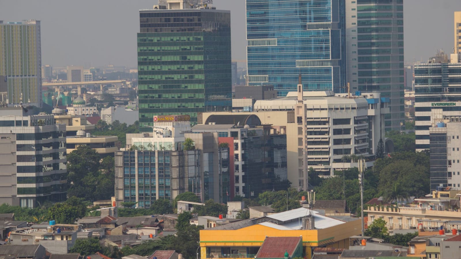 Aerial view of Jakarta's urban skyline showcasing modern skyscrapers and bustling city life.