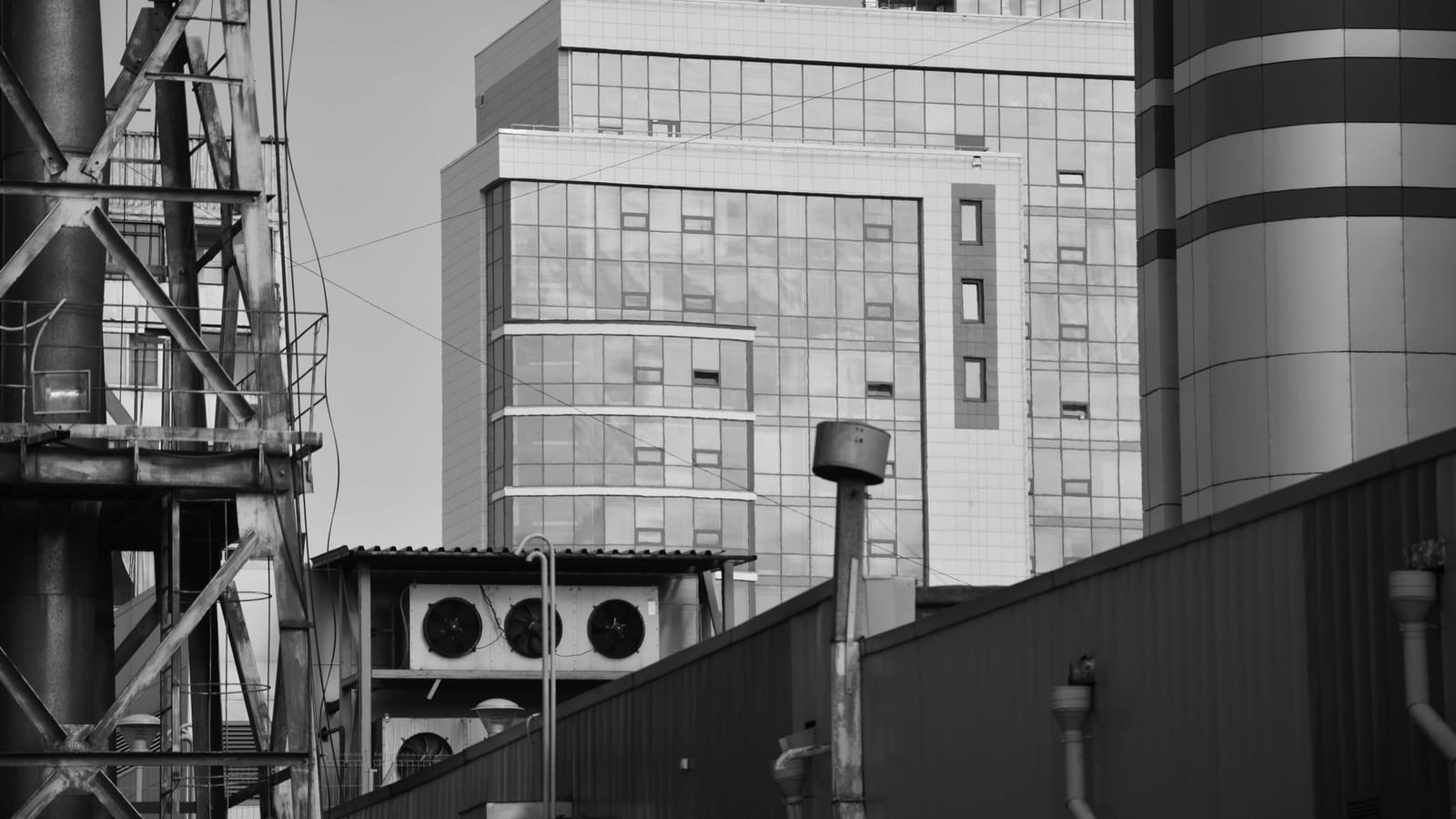 A contemporary industrial facility featuring a sleek glass facade and structural steel elements.