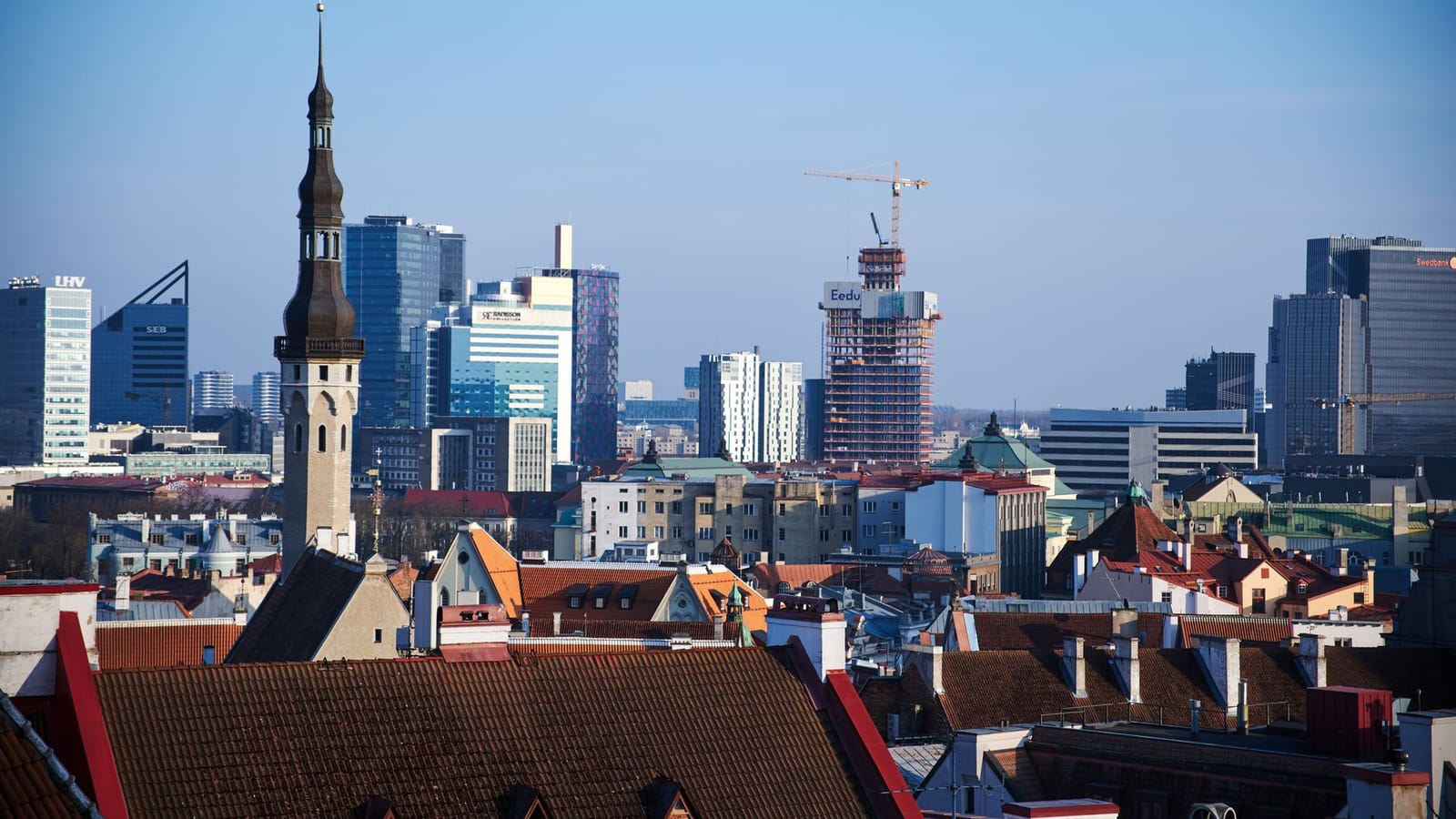 A stunning aerial view of Tallinn's historic and modern skyline with red rooftops and skyscrapers.