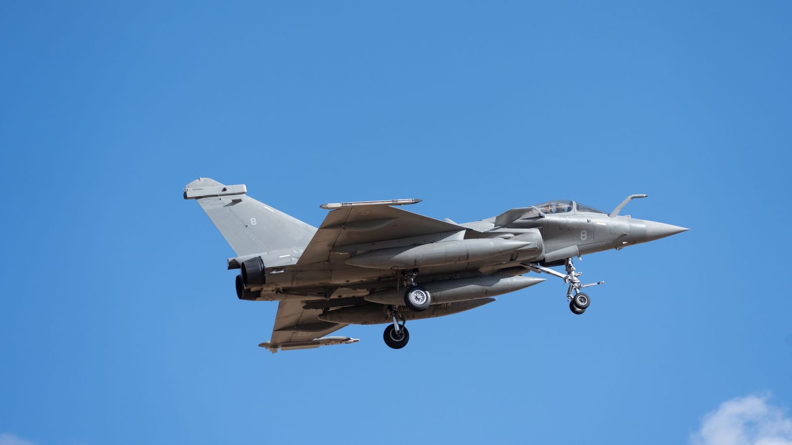 Rafale fighter jet in flight against a clear blue sky over Albacete, Spain.