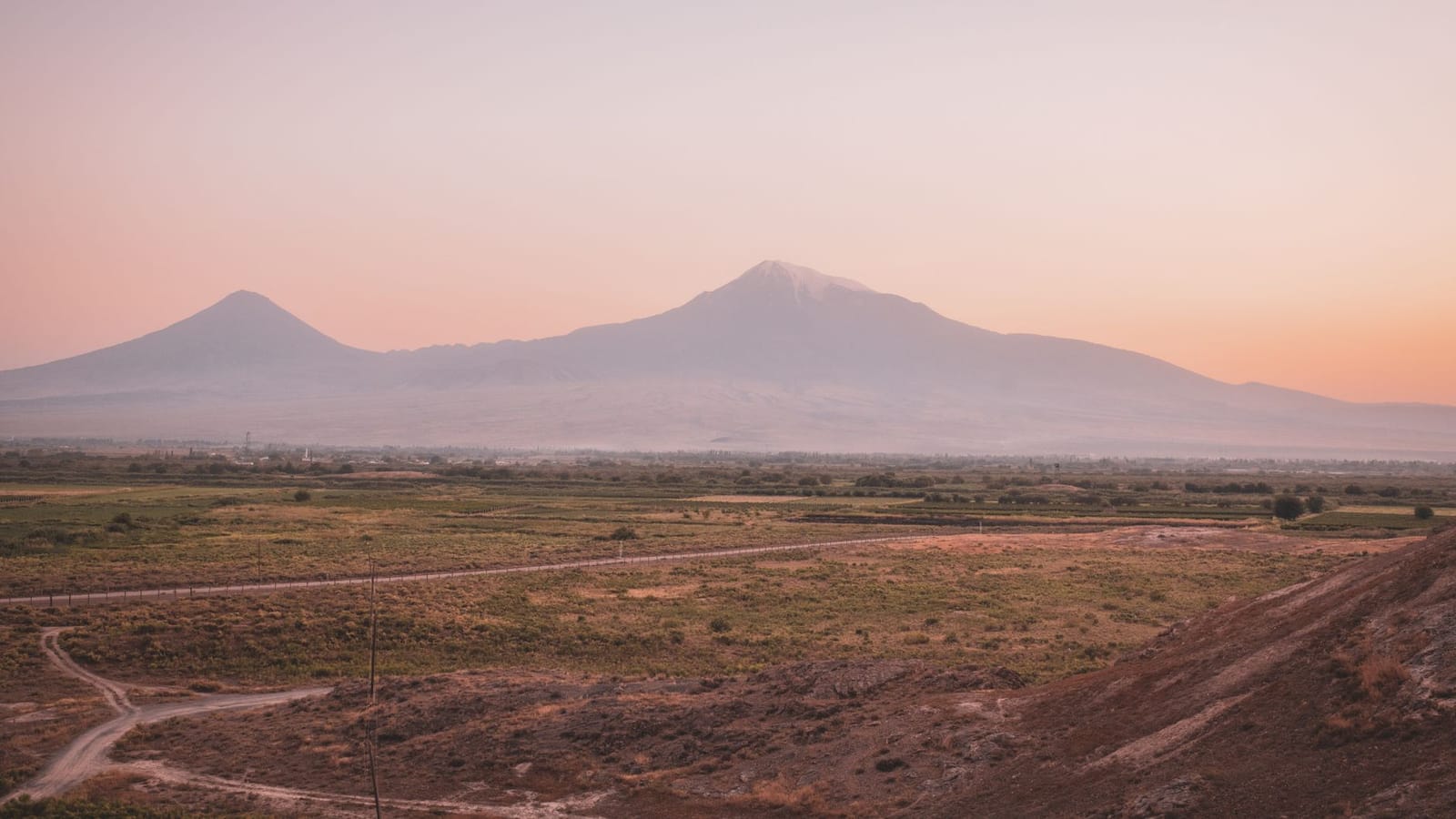 A beautiful view of Mount Ararat at sunset with a warm pink sky in the horizon.