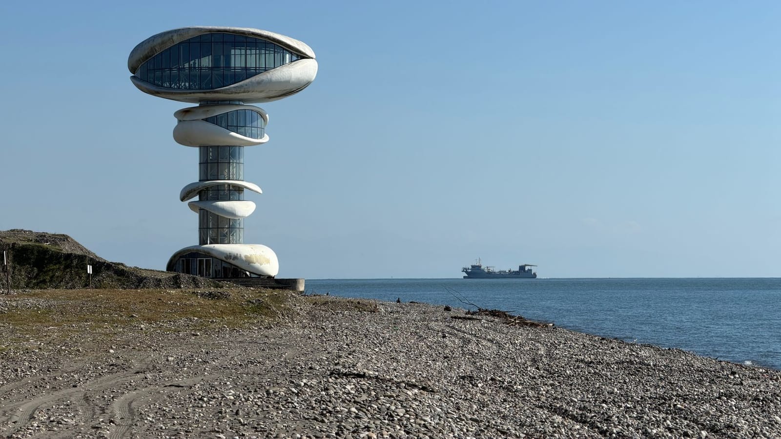 A striking modern tower stands beside the tranquil sea on Anaklia Beach, Georgia.