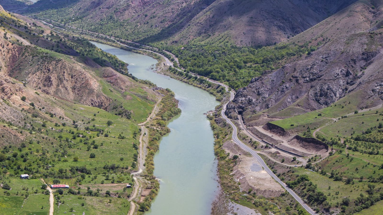 Stunning aerial view of the Euphrates River winding through Palu, Elazığ, Türkiye, showcasing lush green landscapes and rugged mountains.