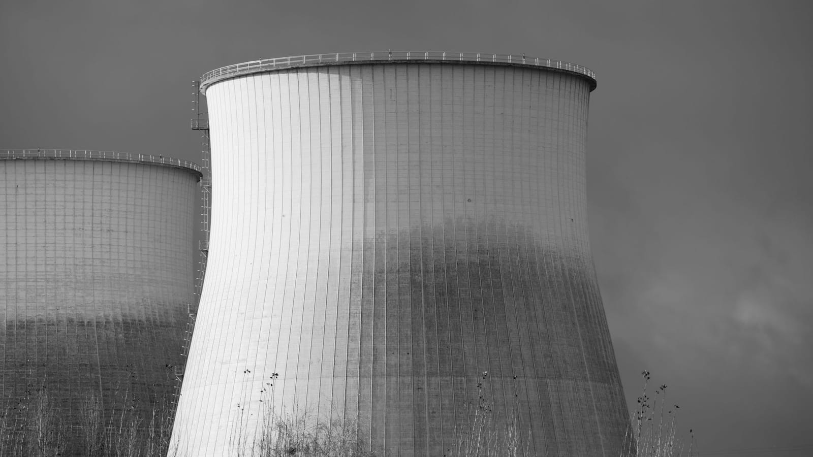 Elegant black and white depiction of cooling towers at a nuclear power station, symbolizing energy and industry.