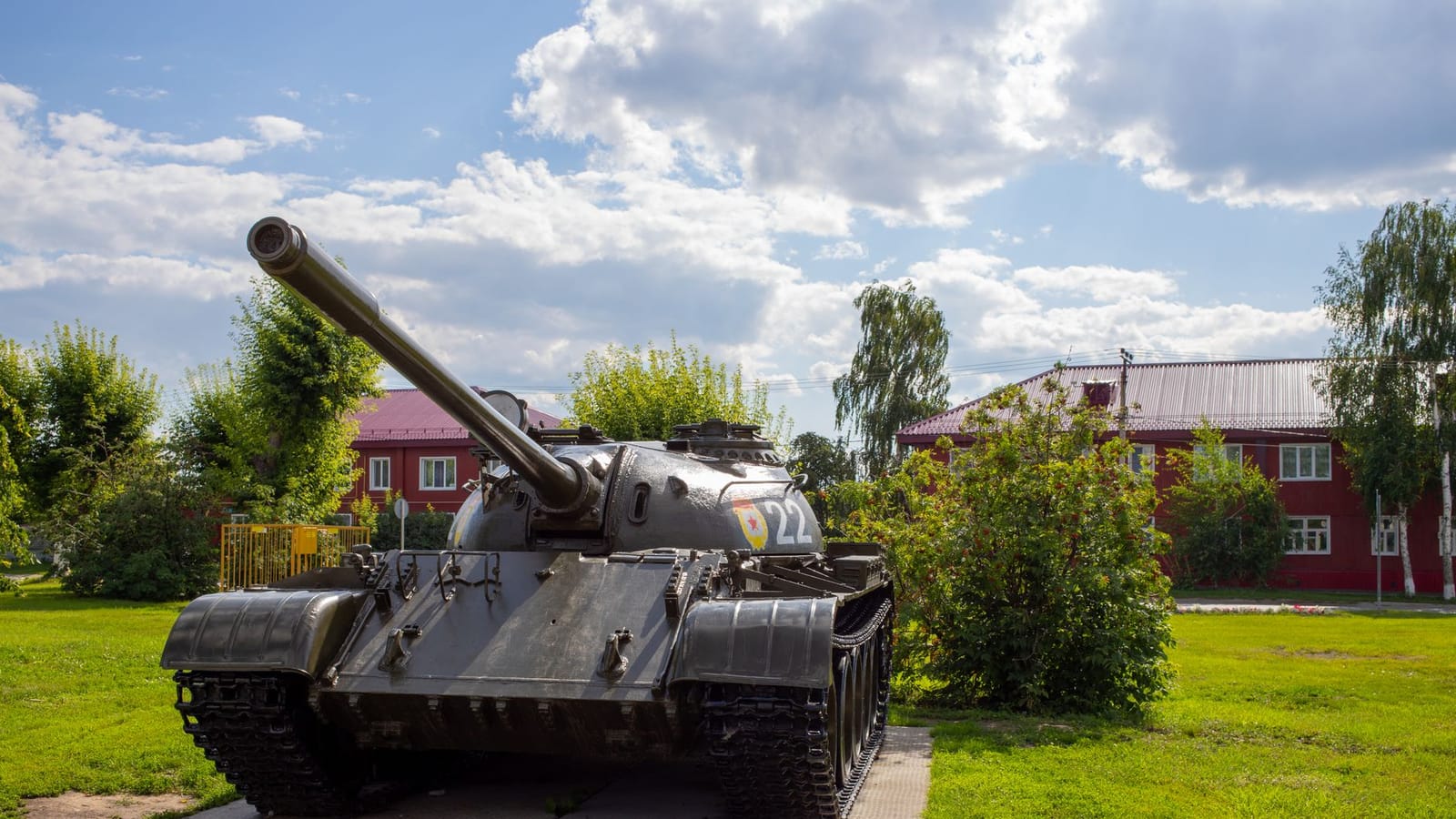 Classic military tank on display in a sunny park setting, showcasing history.