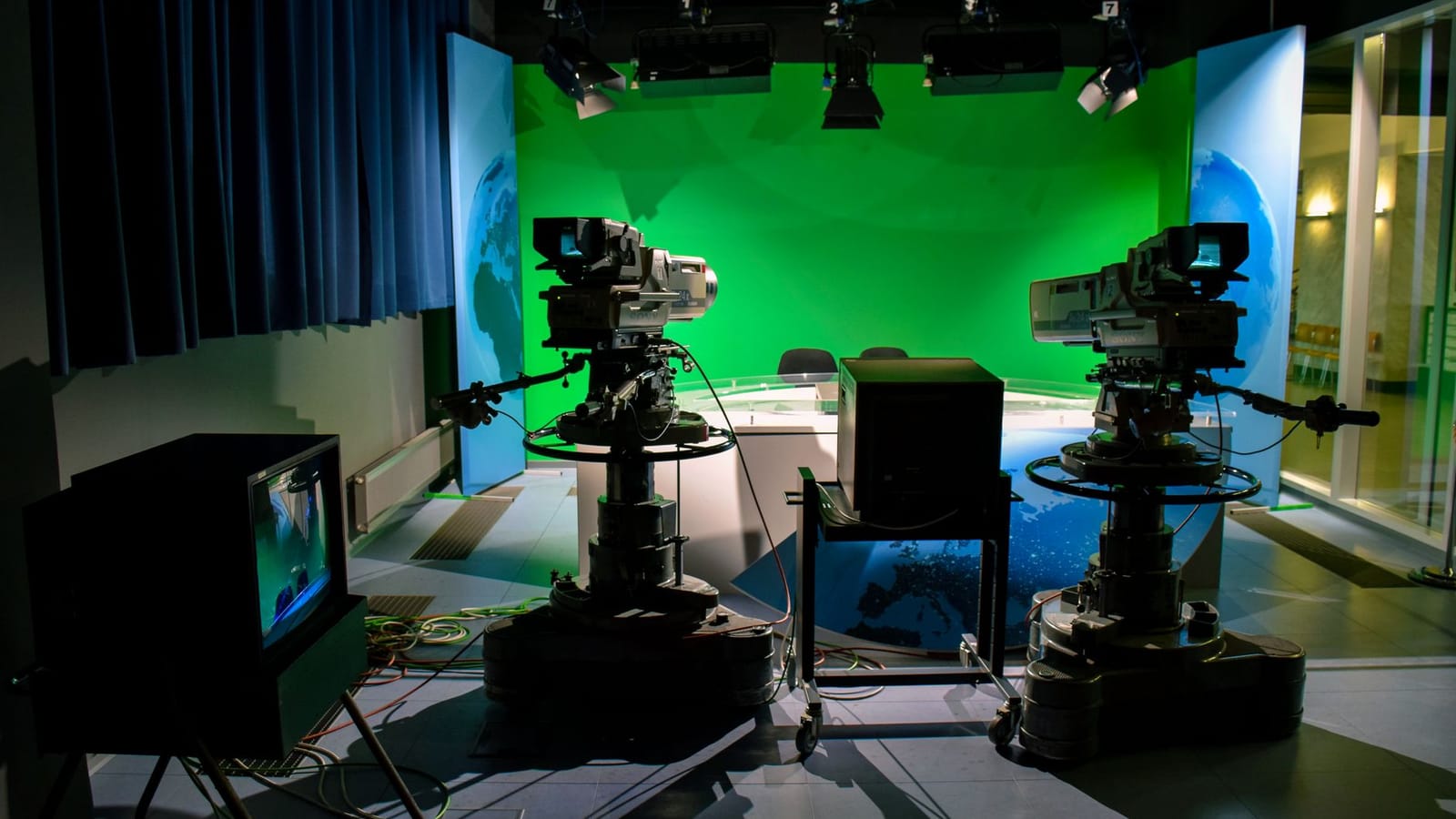A TV studio setup featuring cameras and a green screen for production purposes.