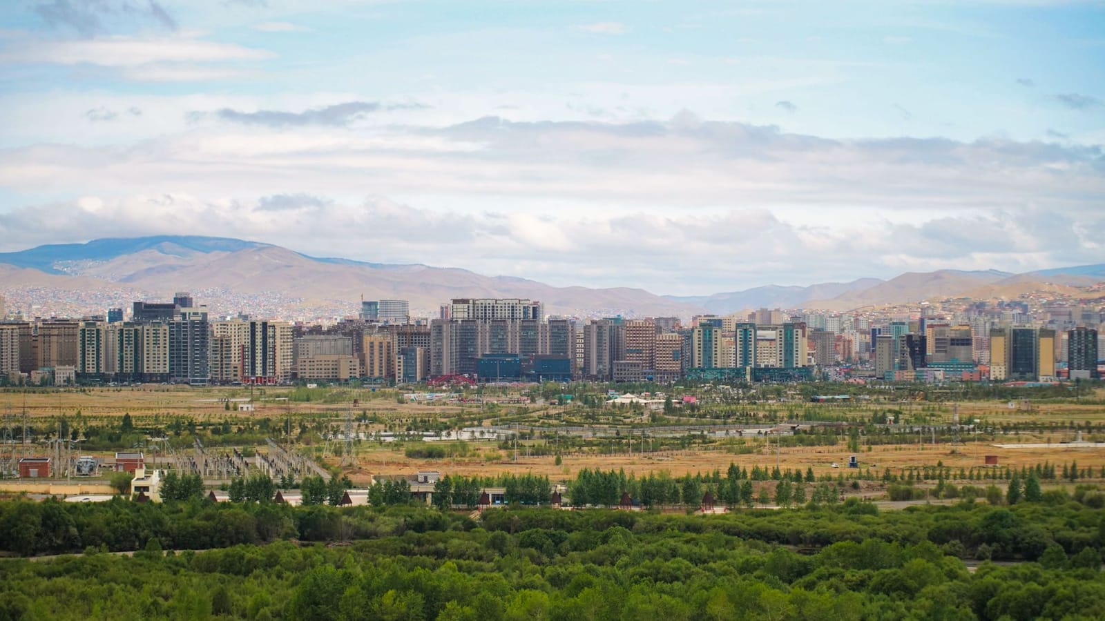 Panoramic view of Ulaanbaatar with greenery and mountains in Mongolia.