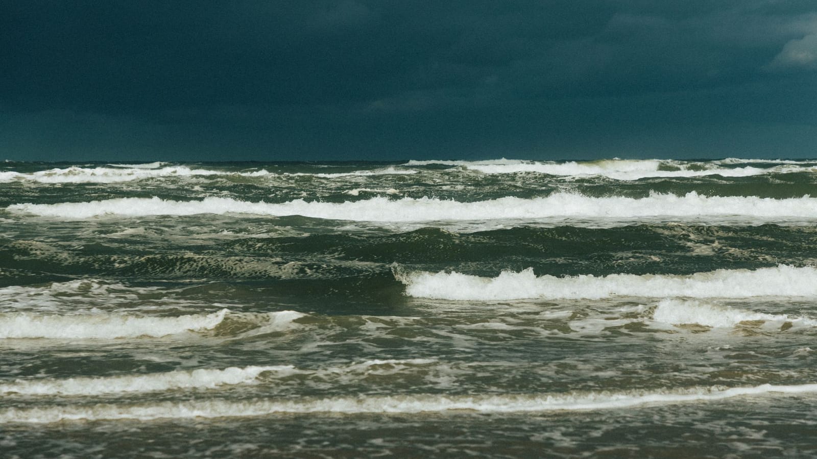 Captivating view of a stormy sea under dark clouds, showcasing powerful ocean waves.